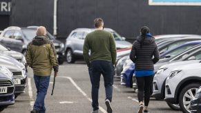 Potential car shoppers walk around Charles Hurst Usedirect used car dealership on Boucher Road