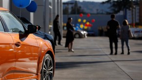 A group of people at a car dealership shopping for a new car