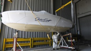 A worker polishes the bottom of a boat at the Chris-Craft manufacturing facility in Sarasota, Florida in June 2018