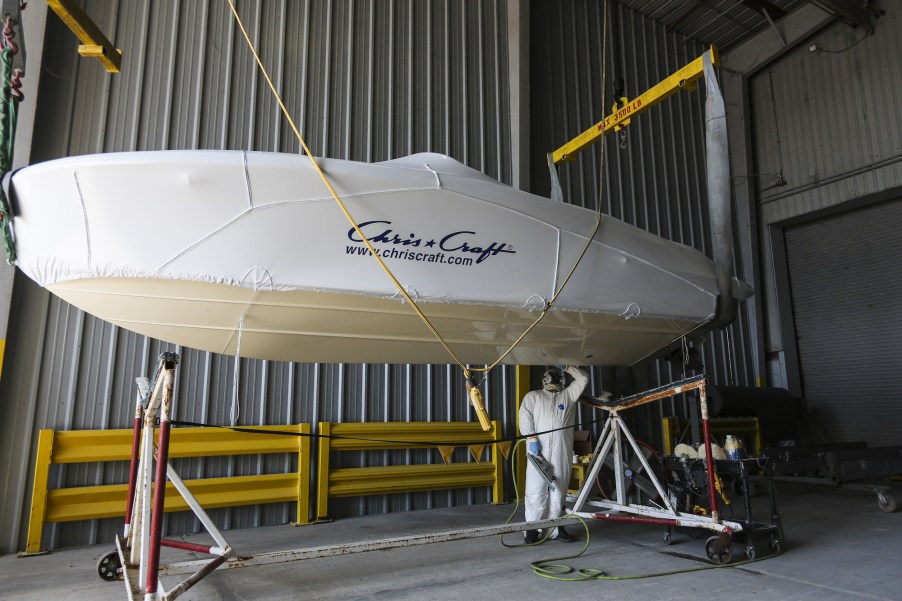 A worker polishes the bottom of a boat at the Chris-Craft manufacturing facility in Sarasota, Florida in June 2018