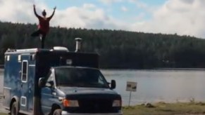 Amanda doing tree pose on the roof deck of her Ford E-350 ambulance camper van