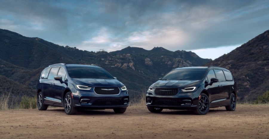 two 2021 Chrysler Pacifica models parked in the dirt in front of mountains