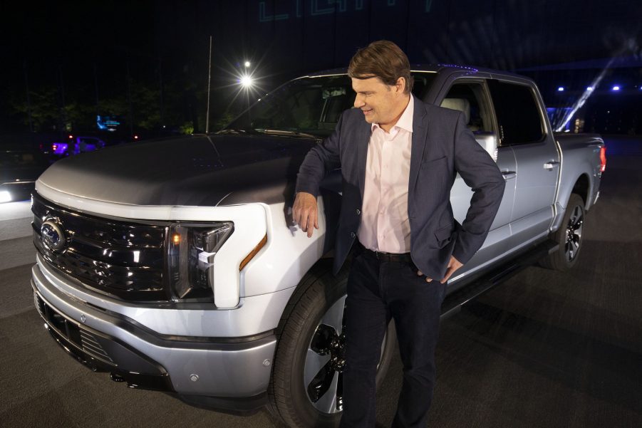 Jim Farley, CEO of Ford Motor Company, poses with the new all-electric silver F-150 Lightning performance truck at its reveal at Ford World Headquarters