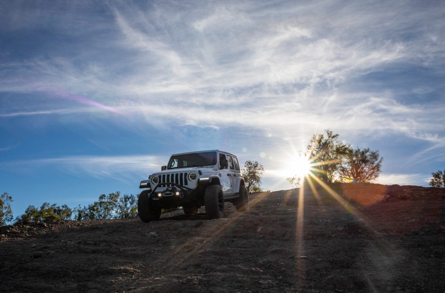 The Jeep Wrangler is the SUV with the best resale value partly because of the off-road prowess demonstrated by this white Wrangler climbing down a rocky hill