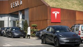 A grey Tesla Model Y sits outside a showroom