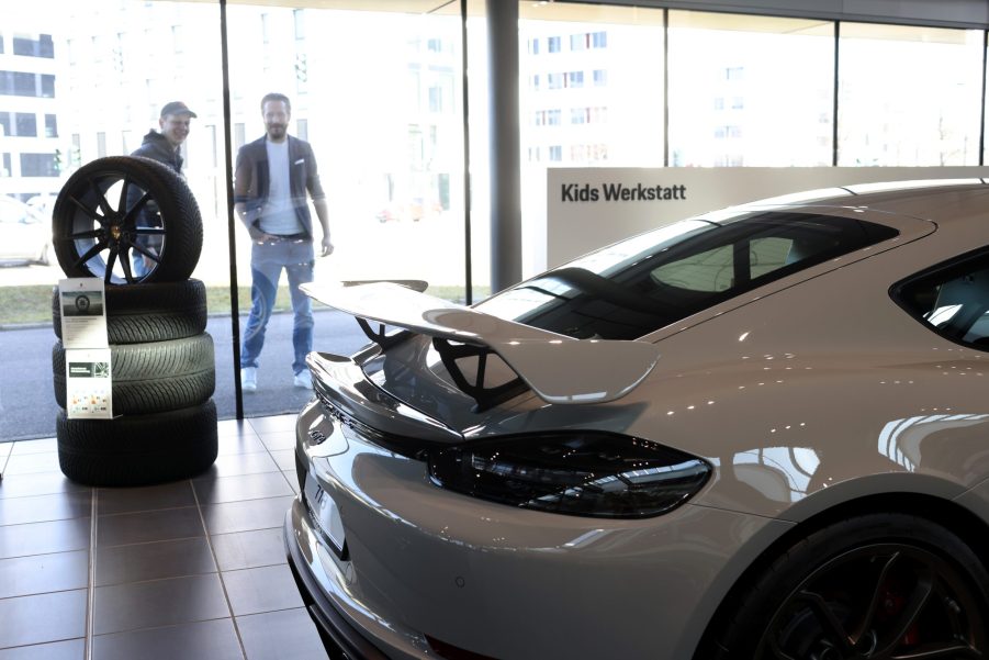 the rear wing of a white 2022 Porsche 911 GT3 in a showroom