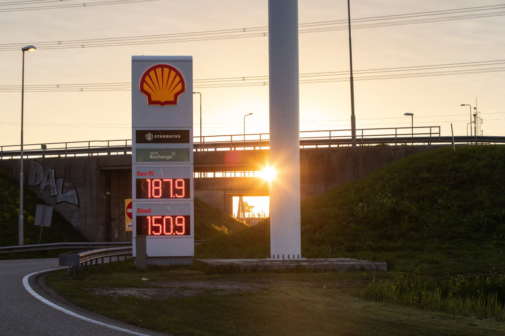 The sun sets over the highway behind a Shell gas station in Rotterdam