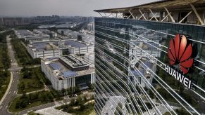 The Huawei logo on the front of a tall production campus building