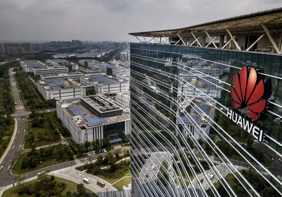 The Huawei logo on the front of a tall production campus building