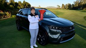 Inbee Park of South Korea poses with the winner’s trophy and her black 2021 Kia Sorento after her -14 under par victory during the Final Round of the KIA Classic at the Aviara Golf Club