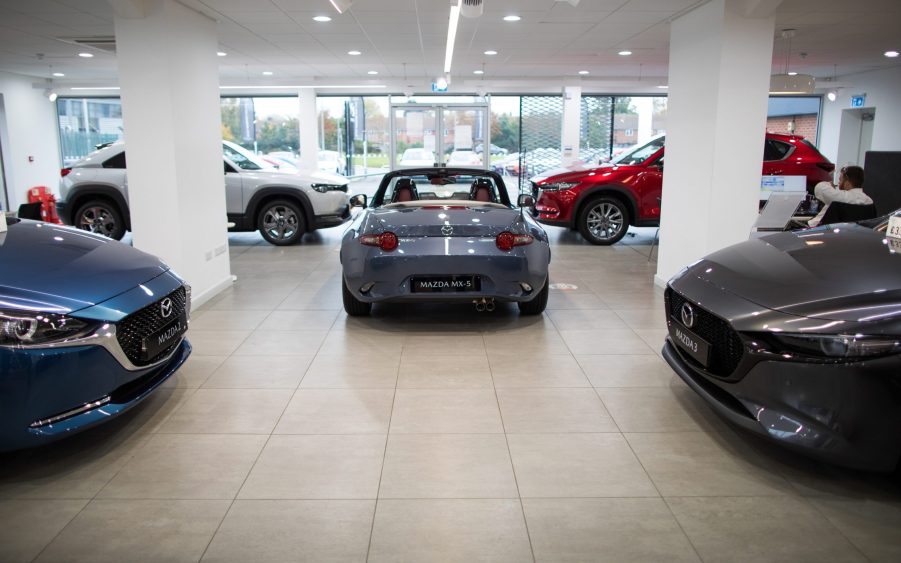 Automobiles manufactured by Mazda Motor Corp., including a gray Mazda MX-5 Miata, centre, in the showroom of a dealership