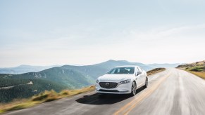 A white Mazda6 driving on a street