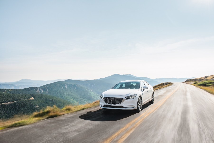 A white Mazda6 driving on a street