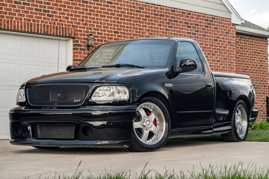 A black modified 2002 Ford F-150 SVT Lightning by a brick building