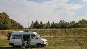 RVers in a Volkswagen Transporter T4 van boondocking on a river bank