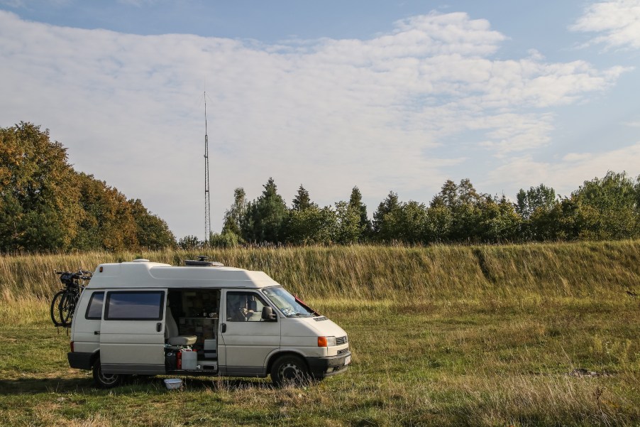 RVers in a Volkswagen Transporter T4 van boondocking on a river bank