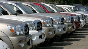 A row of pickup trucks sits on a lot.