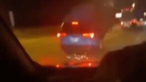 An image of a Toyota RAV4 crashing on the highway after going over a tire.