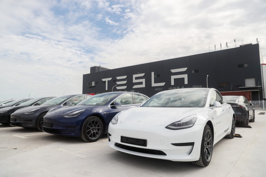 A lineup of Tesla Model 3s, one of the best luxury EVs according to Truecar