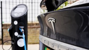 A Tesla plugged in at a charging station, multiple Tesla models are among the best-selling EVs