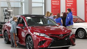 Visitors to the Toyota Motor Manufacturing plant look over the red 2019 Toyota Camry at the Georgetown plant