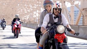 Two riders dressed in vintage clothing ride over a NYC bridge at the 2018 Distinguished Gentleman's Ride