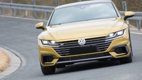 A gold VW Arteon performs a test drive near a Volkswagen manufacturing plant.