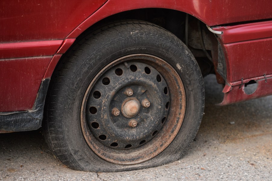 Close-up of a flat tire on a red car