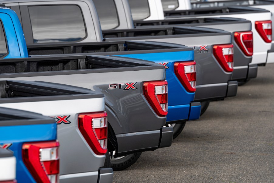 a row of 2021 Ford F-150 pickup trucks in a row on the sales lot