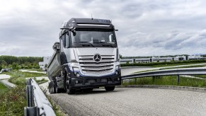 A silver and black Mercedes-Benz hydrogen tuck comes up a hill