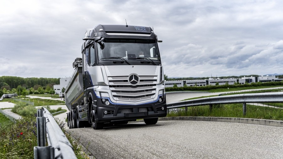 A silver and black Mercedes-Benz hydrogen tuck comes up a hill