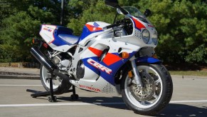 A white-red-and-blue 1993 Honda CBR900RR Fireblade on a rear-wheel stand