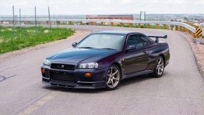 A Midnight Purple II 1999 R34 Nissan Skyline GT-R V-Spec on a road