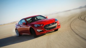 A red 2014 Hyundai Genesis Coupe driving, the 2014 Hyundai Genesis Coupe is one of the fastest used cars under $15,000