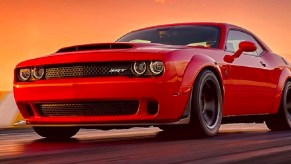 A red 2018 Dodge Challenger Demon against an orange setting sun.