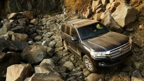 A dusty black 2020 Toyota Land Cruiser full-size SUV parked on a rocky mountainside