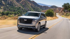 A 2021 Cadillac Escalade driving down a curvy road