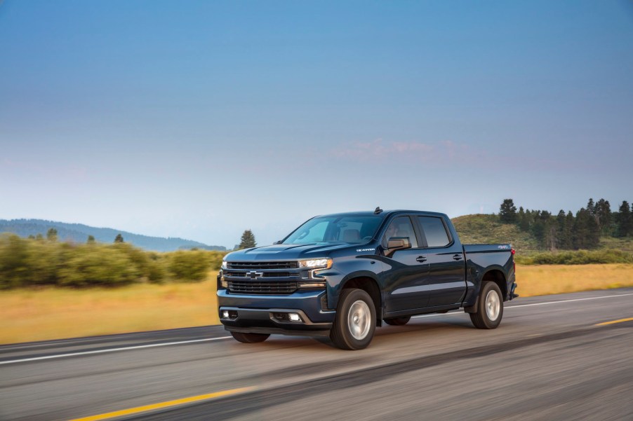 A blue 2021 Chevrolet Silverado driving on the road