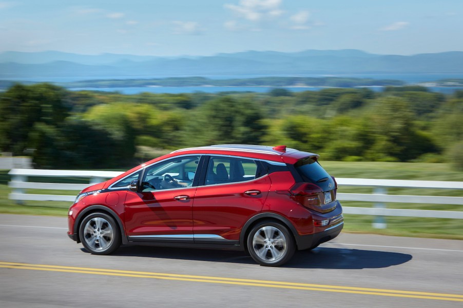 A red 2021 Chevrolet Bolt EV driving, the 2021 Chevrolet Bolt EV is one of the cheapest new electric cars of 2021 and killed on Consumer Reports