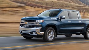 A blue 2021 Chevy Silverado races down the highway.