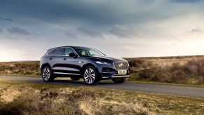 A navy-blue 2021 Jaguar F-Pace PHEV luxury compact SUV parked on a rural road