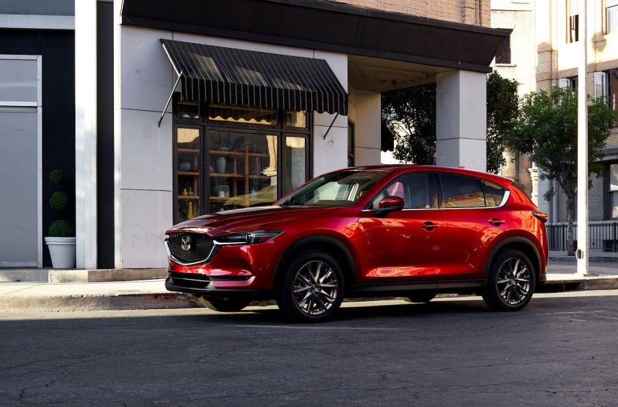 A red 2021 Mazda CX-5 parked in the city, the 2021 Mazda CX-5 is one of the best new SUVs under $30,000