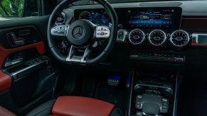 The red-and-black-leather interior of a 2021 Mercedes-AMG GLB 35 with its MBUX infotainment system active