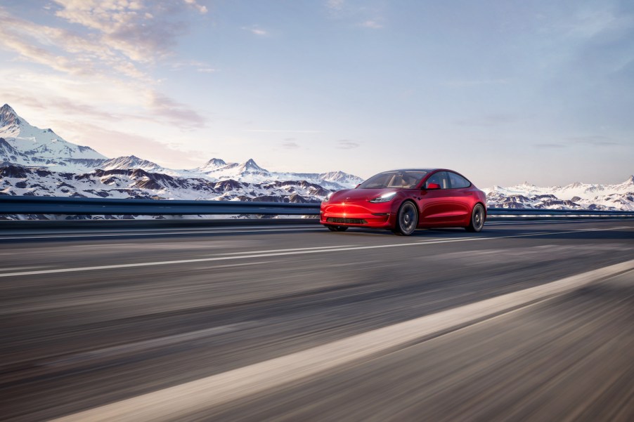 A red 2021 Tesla Model 3 driving along the mountains, the 2021 Tesla Model 3 is one of the best new sports cars with all-wheel drive