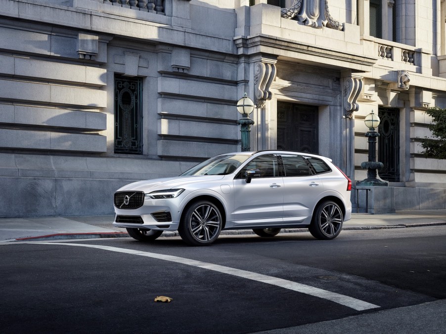 A 2021 Volvo XC60 Recharge Plug-In Hybrid R-Design in Crystal White Pearl stopped on a city street