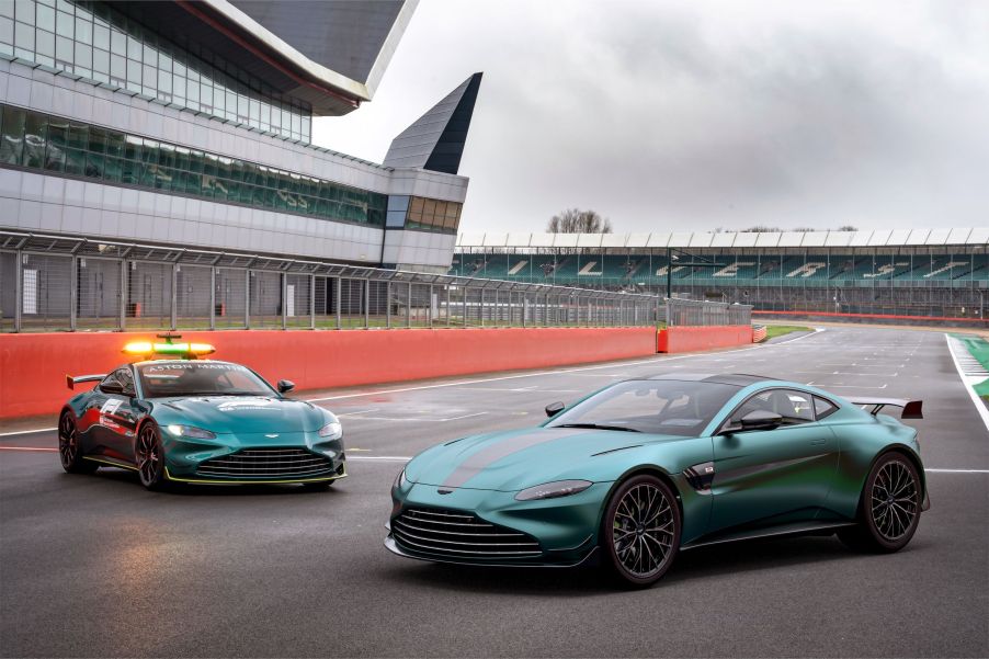 A green 2022 Aston Martin Vantage F1 Edition to the right of the green Vantage F1 safety car on a racetrack