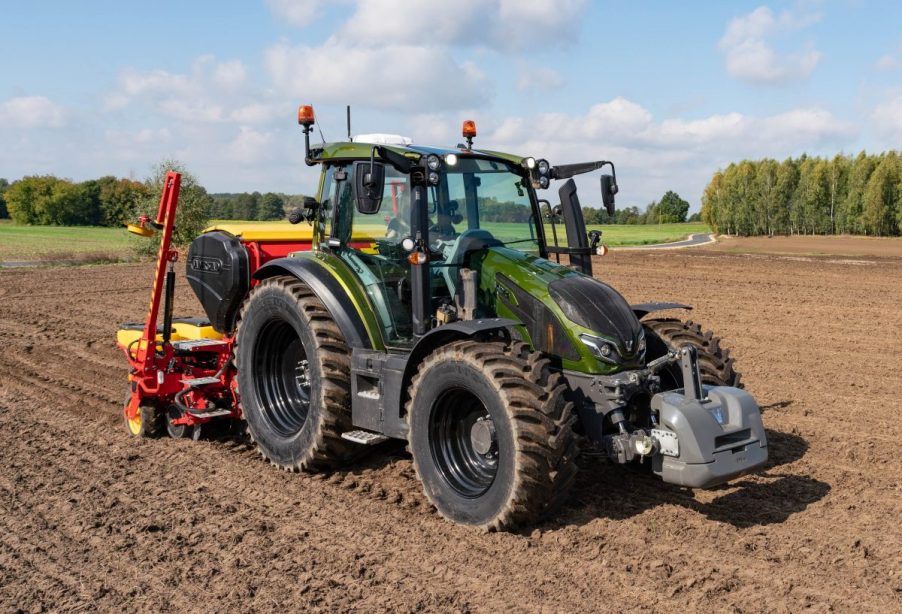 Valtra G 135 Versu utility tractor model in a crop field on a sunny day