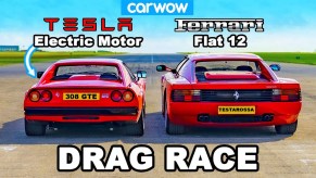 A red Tesla-swapped Ferrari 308 GTS next to a red Ferrari Testarossa on a British airstrip