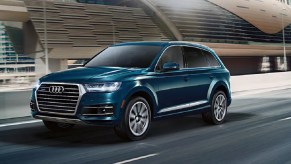 A blue 2021 Audi Q7 driving down a highway.