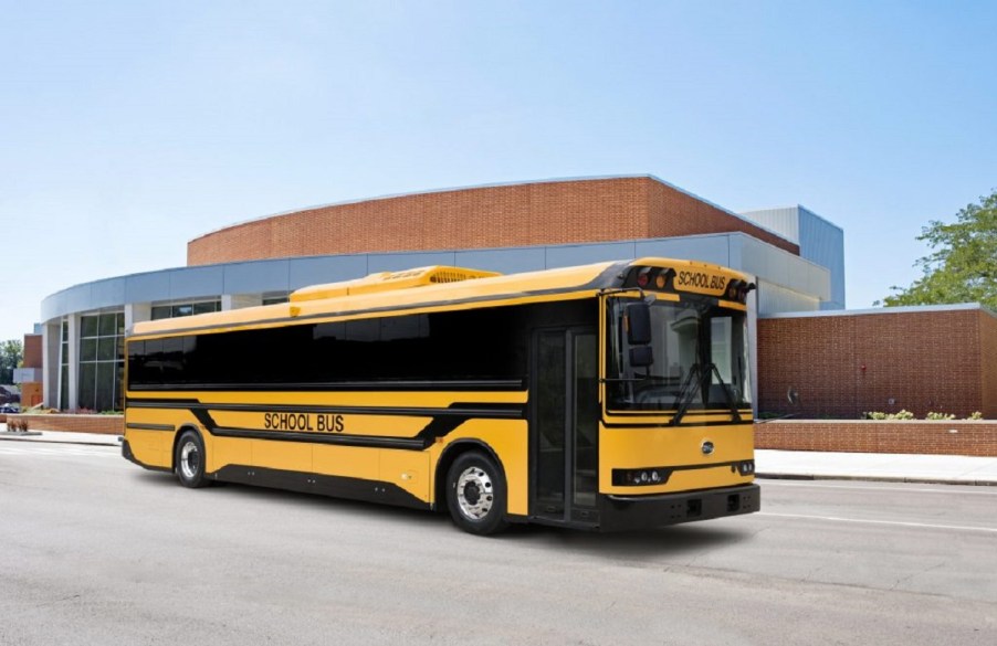 A yellow BYD electric school bus driving down a street.